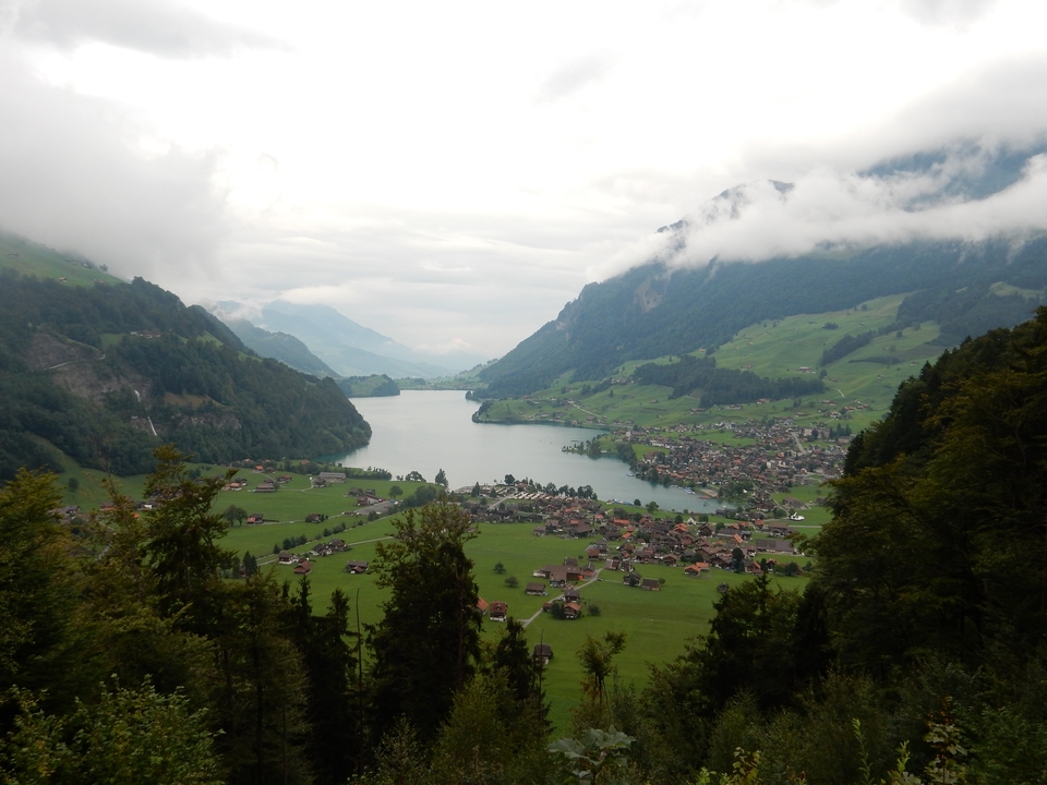 Vue panoramique de la vallée avec un lac entouré de montagnes.