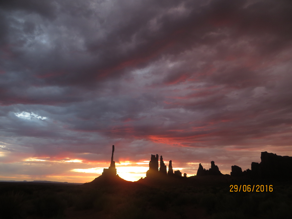 Un coucher de soleil à couper le souffle sur un paysage de formations rocheuses.
