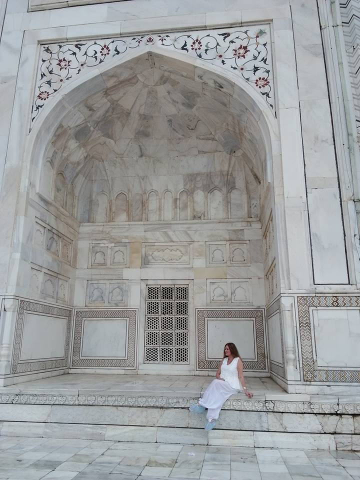 Marble alcoves and jali screens inside a Mughal monument with intricate stonework.
