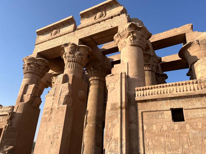 Close-up of towering stone columns with intricate hieroglyphs at Kom Ombo Temple.