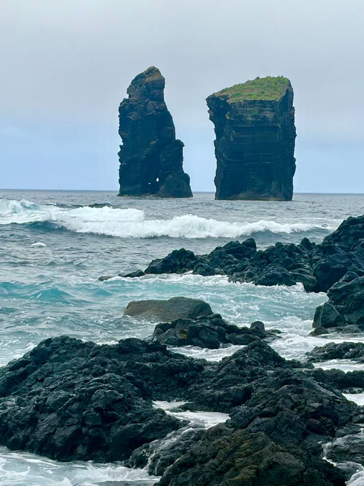 Rugged basalt sea stacks rise from crashing Atlantic waves.