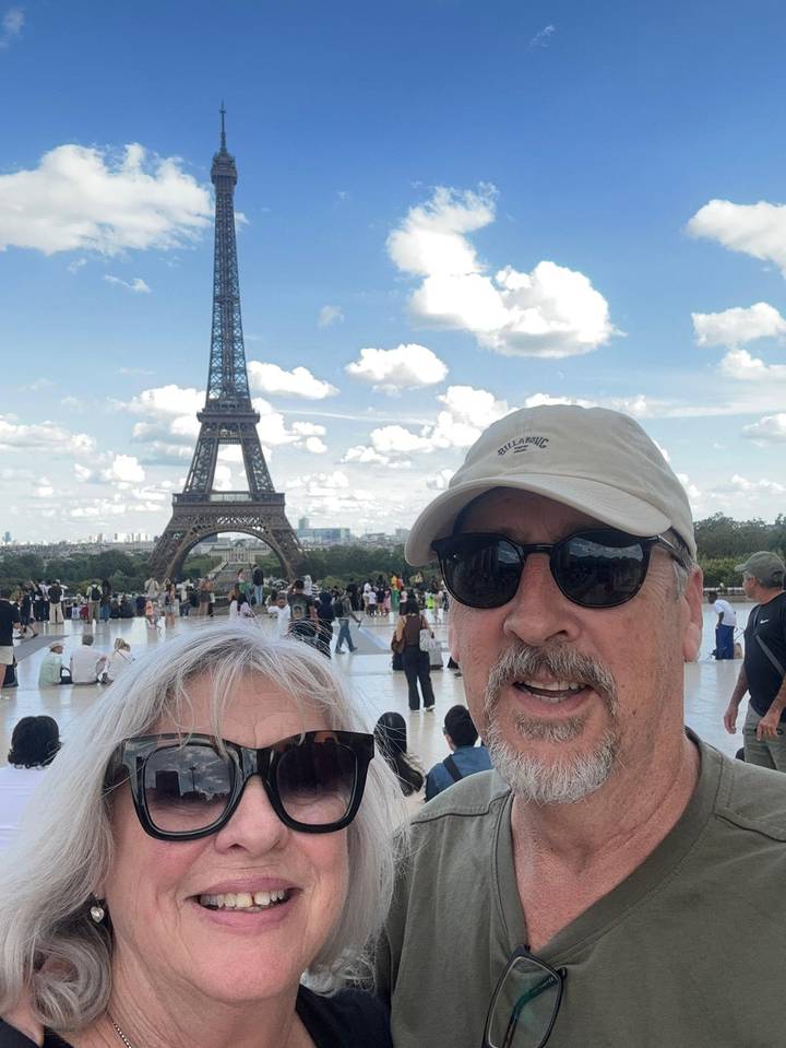 Couple takes a selfie at Trocadéro with the Eiffel Tower towering behind on a sunny afternoon.