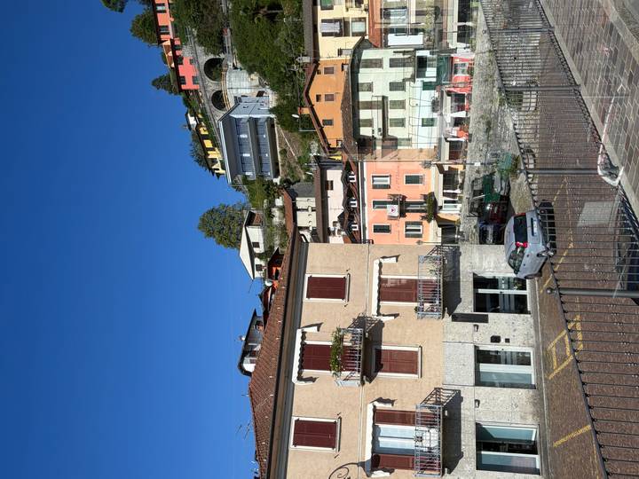 Colorful hillside houses under a deep blue sky in a lakeside Italian village