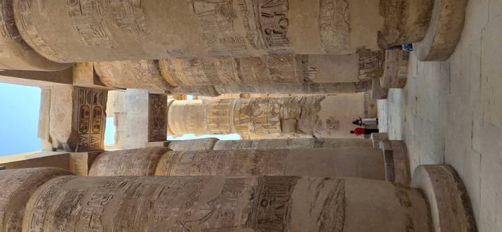 Visitors dwarfed by massive hieroglyph-covered columns in Karnak’s Hypostyle Hall