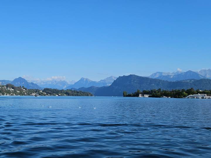 Expansive blue waters of Lake Lucerne framed by forested shores and distant alpine ridges