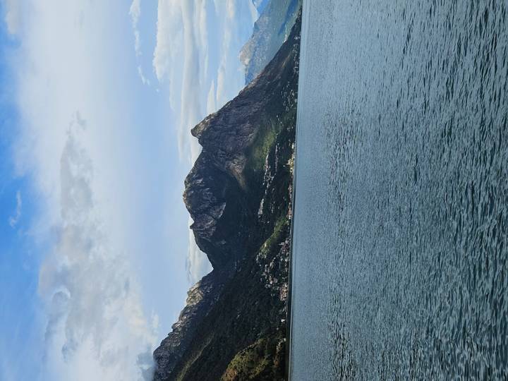 Serene lake bordered by steep forested mountains under a partly cloudy sky near Montreux