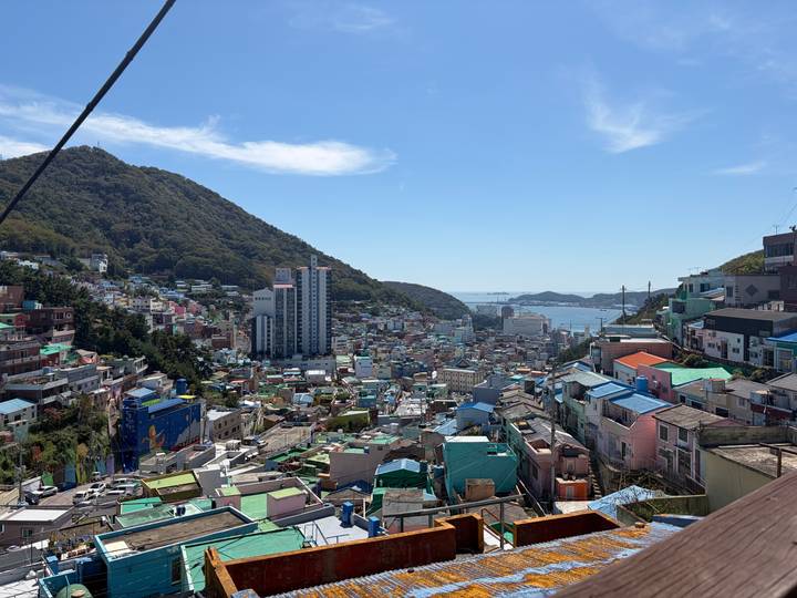 Panoramic view over colourful terraced houses of Busan’s Gamcheon Village toward the harbour.