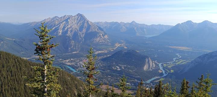Panoramic summit view overlooking Banff townsite, rivers and towering peaks