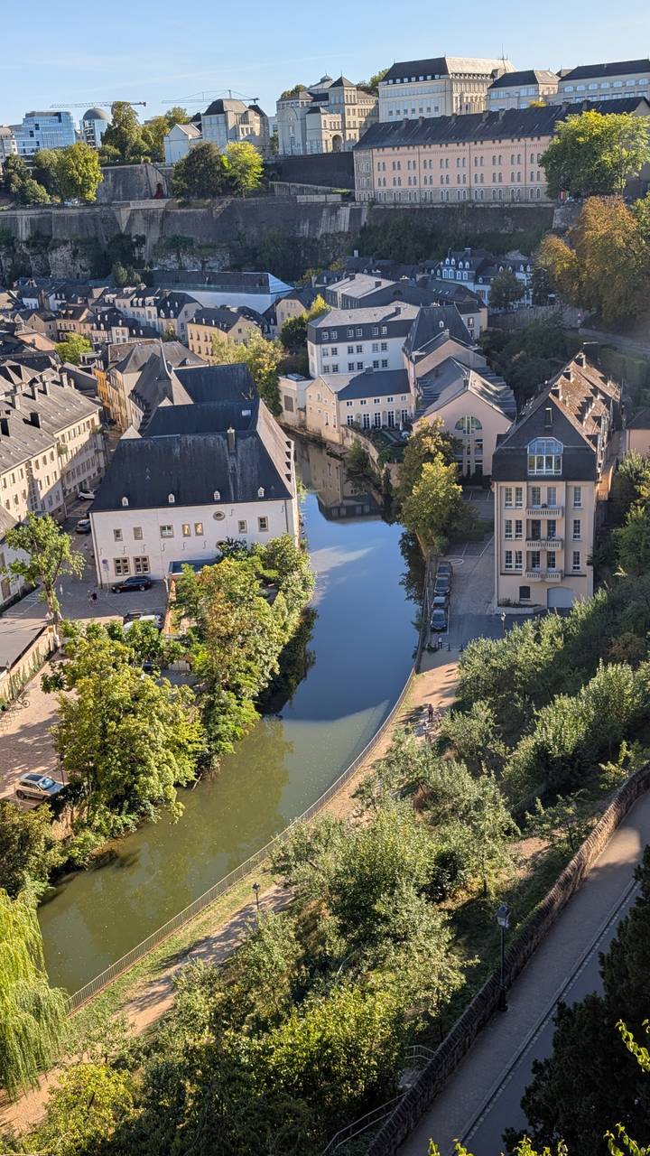 Aerial view of Luxembourg’s Grund district with calm river lined by historic buildings