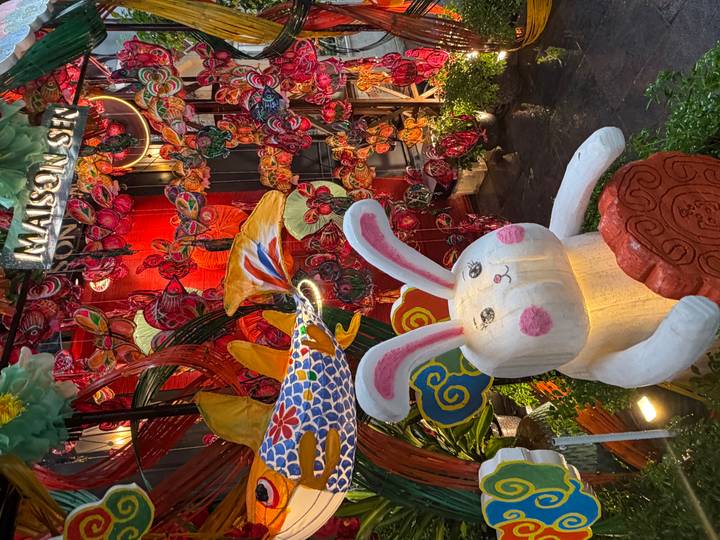 Colourful night display of lanterns, butterflies and a smiling rabbit statue outside Maison Sen.