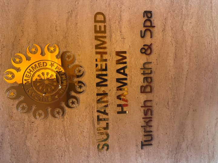 Close-up of a polished wall sign reading 'Sultan Mehmed Hamam Turkish Bath & Spa'.