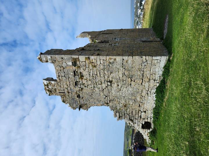 Ruined stone house standing alone on grassy coastal headland