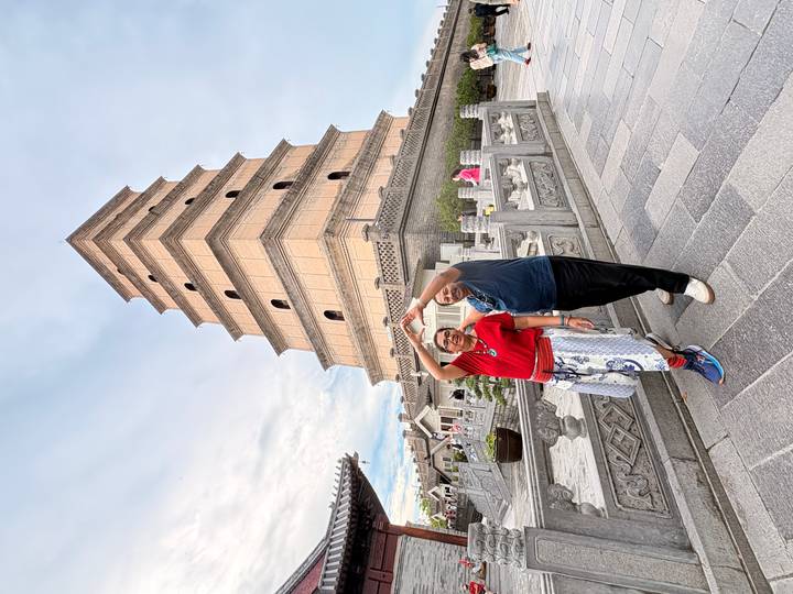 Two travelers posing playfully in front of the Giant Wild Goose Pagoda