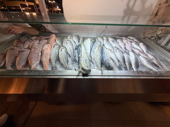 Display case filled with fresh whole fish on crushed ice inside a market or restaurant