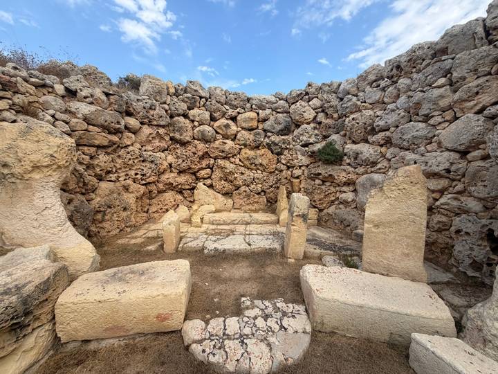 Ancient megalith stone temple remains with stacked weathered rocks under blue sky