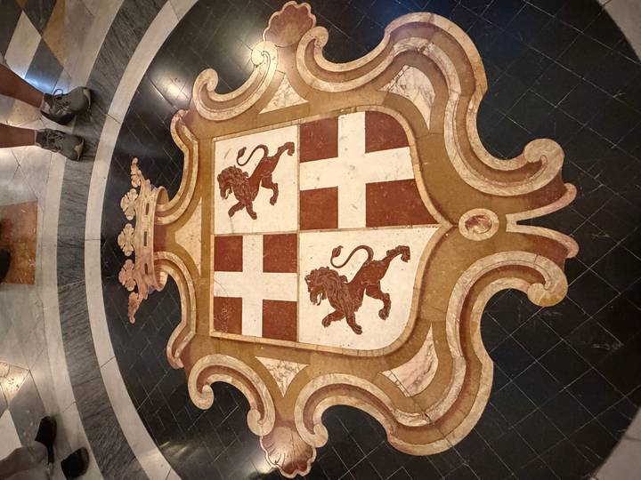 Stone inlaid floor crest with lions and crosses inside a Maltese historic site