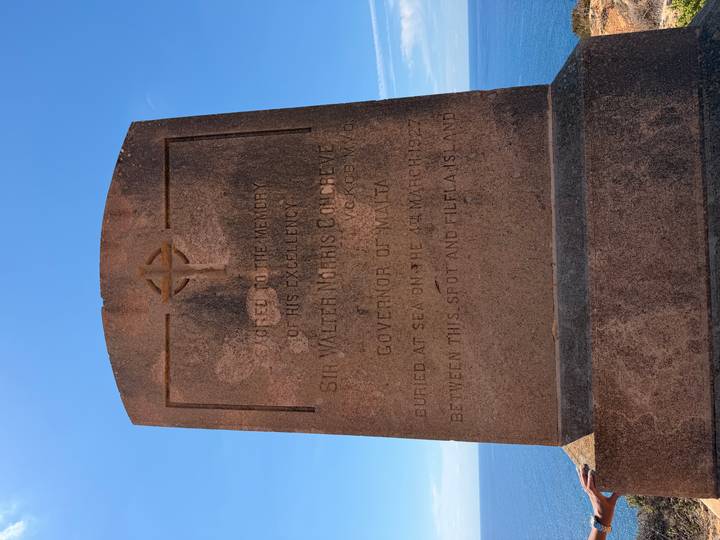 Stone memorial pillar dedicated to Sir Walter Congreve with blue sea backdrop