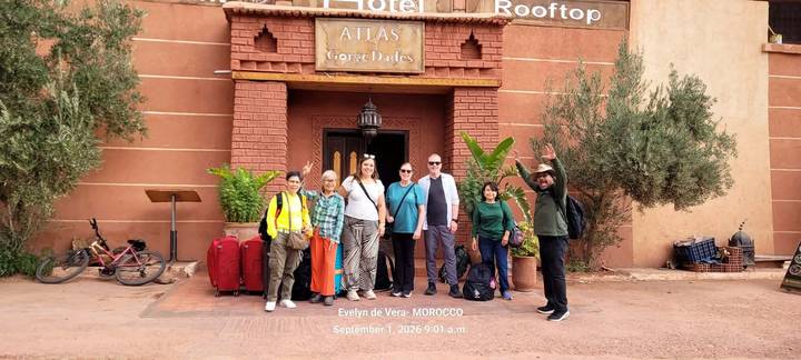 Group photo with luggage outside Atlas Gorge Dades hotel entrance; timestamp text overlay present.