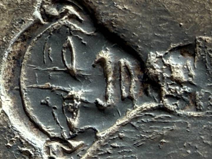 Macro photograph of a weathered stone carving of an ancient Egyptian face showing surface cracks.