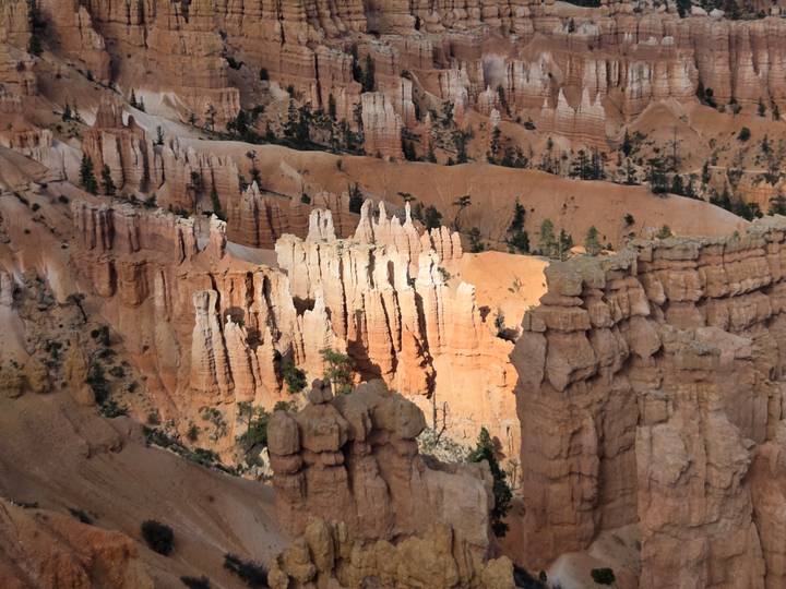 Sunlit hoodoos and striped cliffs create an intricate amphitheater of orange rock at Bryce Canyon.