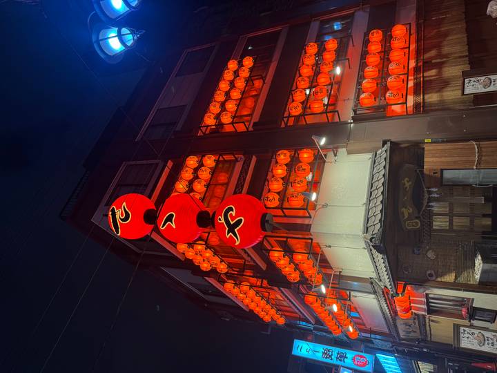 Traditional building illuminated by dozens of red lanterns glowing in the night.
