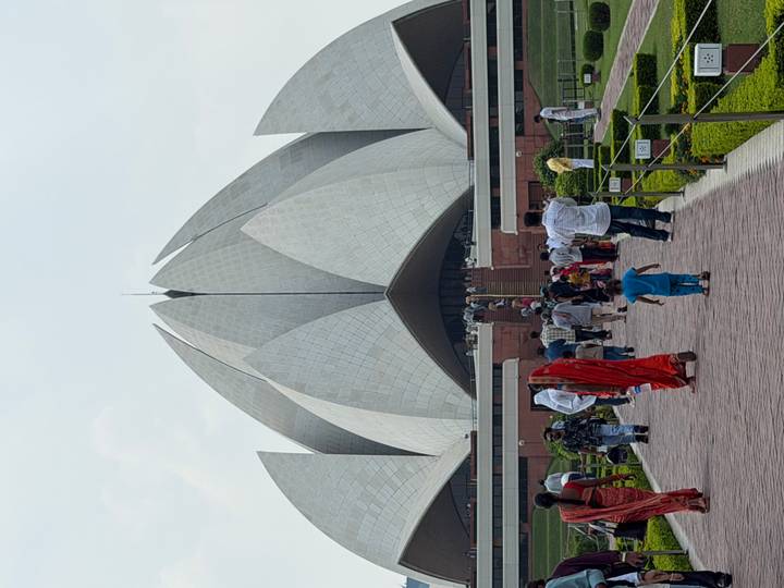 Crowds approach the white petal-shaped Lotus Temple in New Delhi on a hazy day