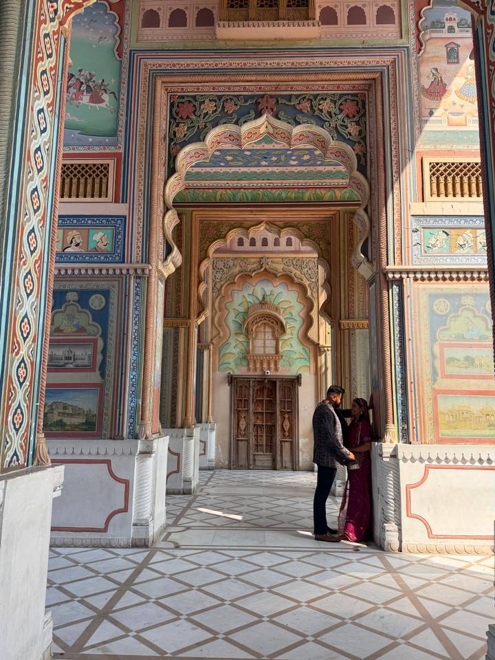 Colorful, highly decorated Patrika Gate with a couple posing at the entrance