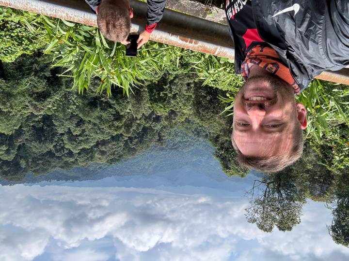 Traveler taking a selfie with lush green mountains and layered valleys stretching into the distance