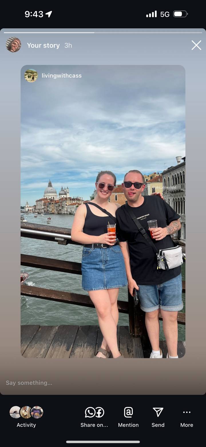 Two travelers pose on a Venetian bridge with Santa Maria della Salute in the background.