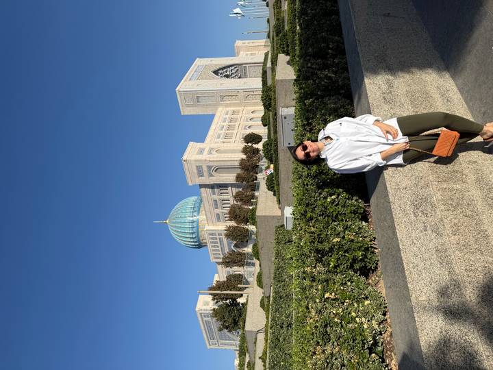 Traveller stands before the grand pale-stone Palace of International Forums topped with a blue dome in Tashkent.