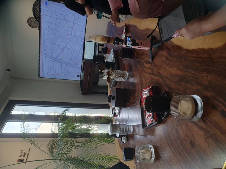 Modern meeting table with coffees and a large wall screen displaying a city map.