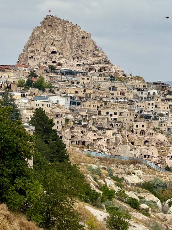 Panoramic view of Cappadocia’s stone houses and cave dwellings cascading down a hillside.