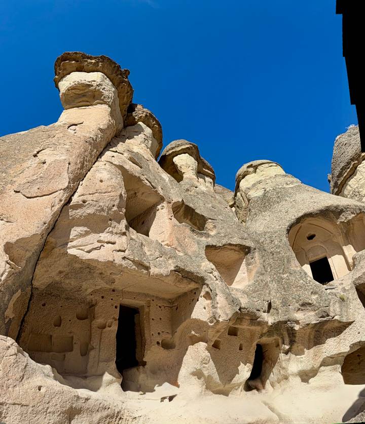 Close-up of Cappadocia fairy-chimney rock formations under a deep blue sky.