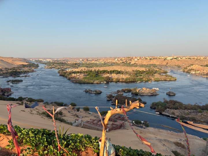 Panoramic view over the Nile winding around rocky islands and desert hills near Aswan at golden hour