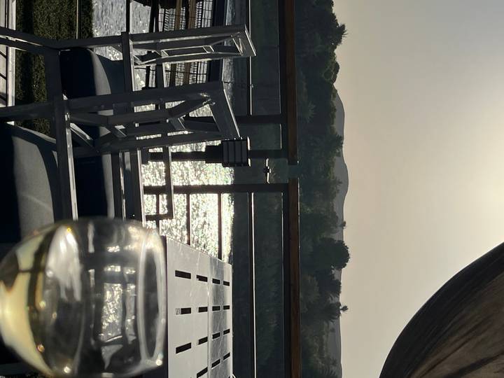 Relaxing deck scene with sparkling Nile waters, silhouetted hills and a glass of white wine at sunset