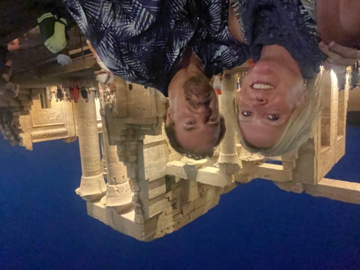 Selfie of a couple at night in front of illuminated columns of Kom Ombo Temple.