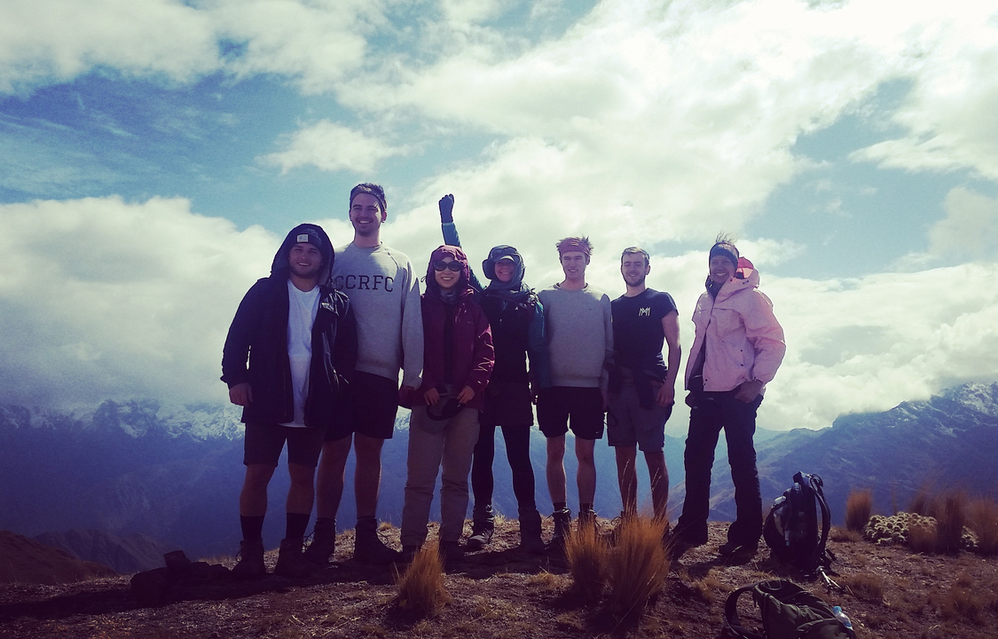 Groupe de personnes posant à un point de vue montagneux.