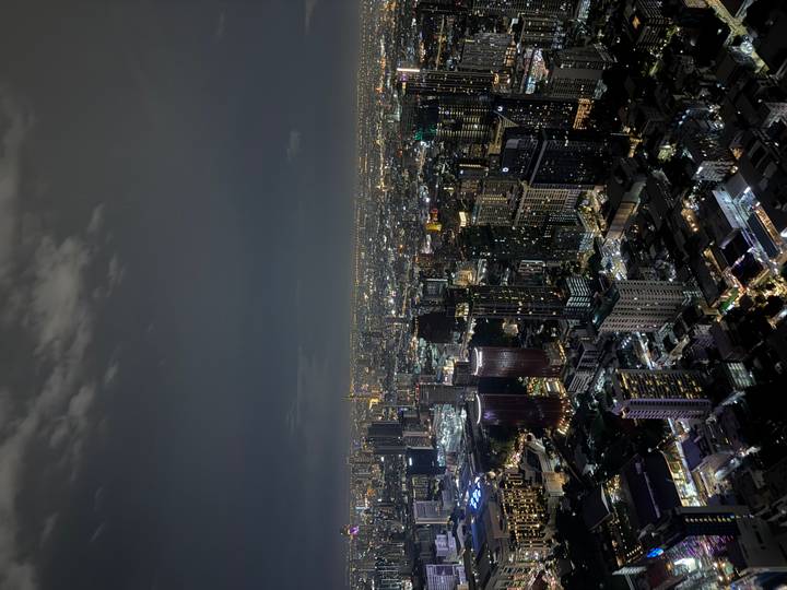 Panoramic night view over Bangkok's illuminated skyline with countless skyscrapers.