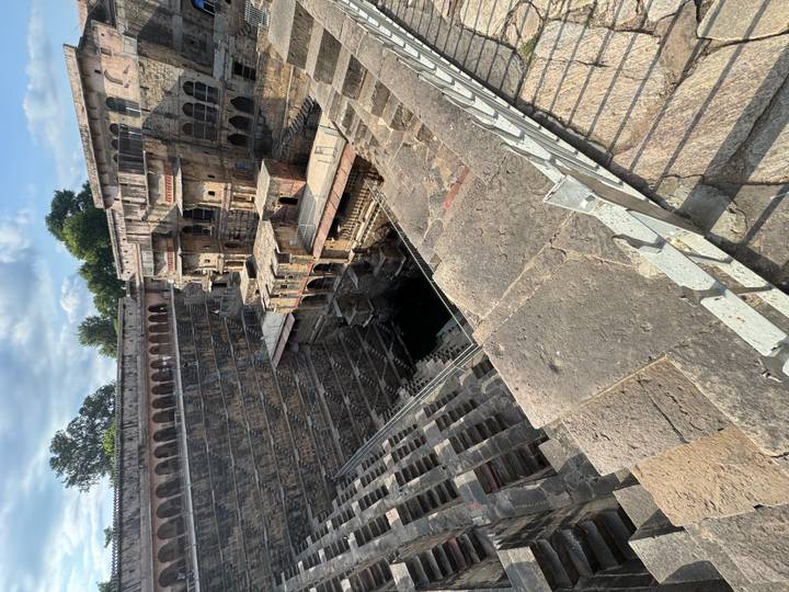 Deep multi-level stepwell with symmetrical stone stair patterns.