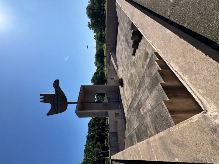 Iconic Open Hand Monument rising against a clear blue sky above a concrete plaza.
