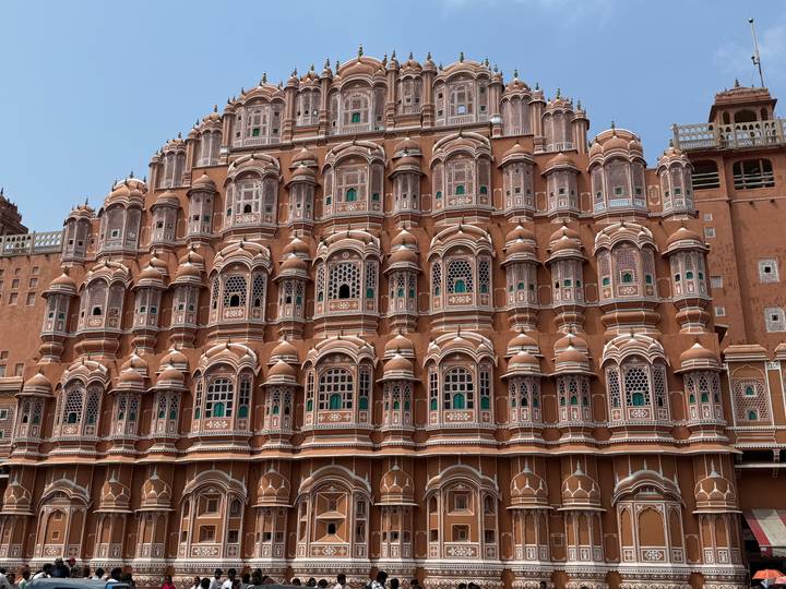 Close-up façade of the terracotta-coloured Hawa Mahal with hundreds of ornate windows.