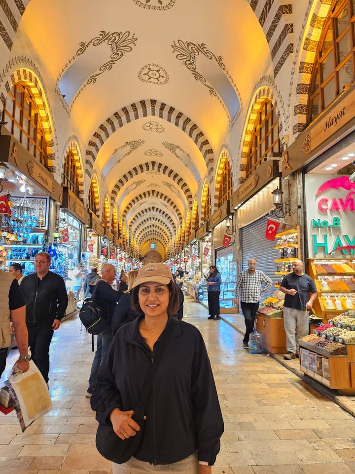 Traveller poses inside Istanbul’s ornate Spice Bazaar with vaulted ceilings and lively stalls.