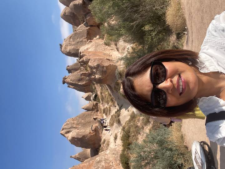 Selfie with Cappadocia’s whimsical fairy-chimney rock spires under bright blue sky.
