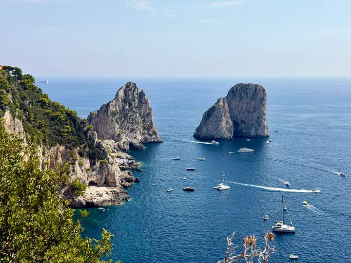 Boats cruise around the dramatic Faraglioni sea stacks off Capri’s rugged coast.