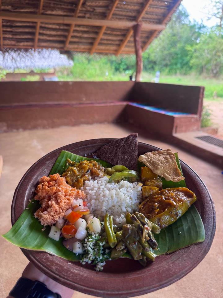 Close-up of traditional Sri Lankan curry plate with rice on banana leaf.