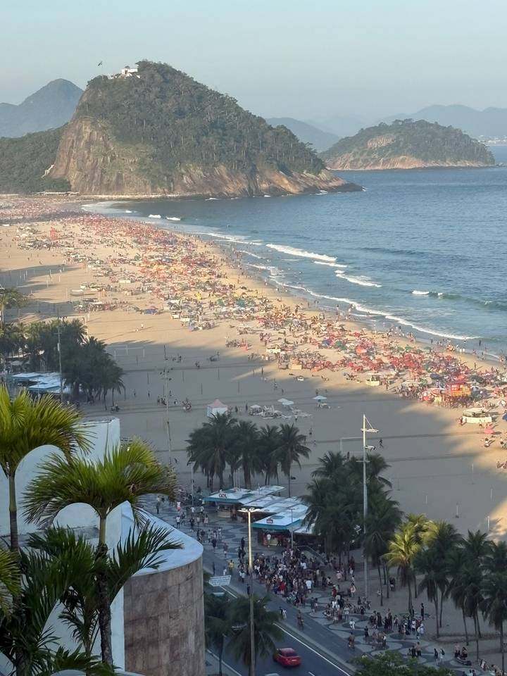 Copacabana Beach packed with colourful umbrellas and bathers viewed from above.