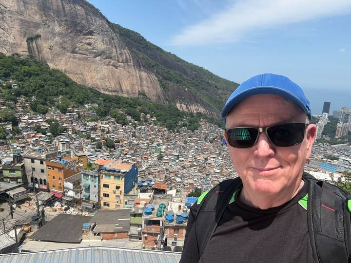 Traveller selfie overlooking a sprawling favela and granite cliffs in Rio de Janeiro.