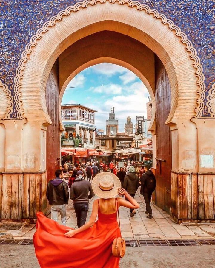 Bustling market street viewed through the ornate Blue Gate arch in Fes