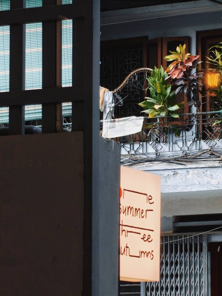 Partial exterior view with wires, plants and an obscured sign; content unclear.