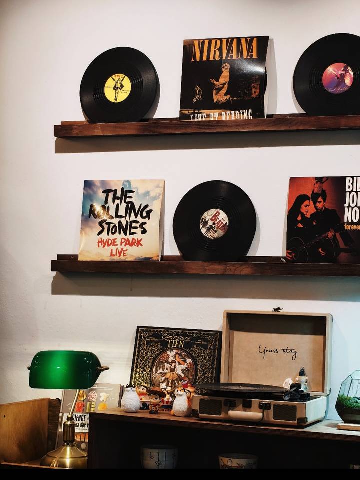 Shelf display featuring a vinyl record and Rolling Stones album cover against a white wall.